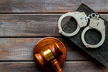 Arrest concept. Handcuffs near judge gavel on dark wooden background top-down copy space