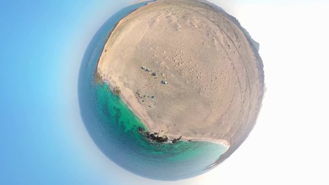 A drone ascends away from a man on a beach before the shot morphs into a dramatic special effect