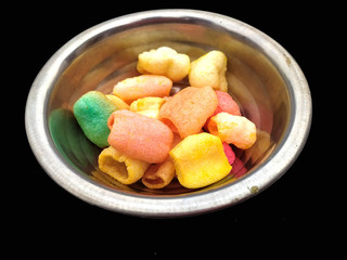 some eatable food put in a  bowl isolated on black  background