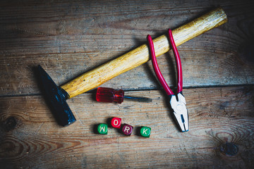 Different tools and the letters work on a wooden surface
