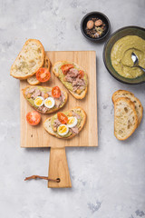 Bruschetta with tuna, tomato, egg, and avocado spread.