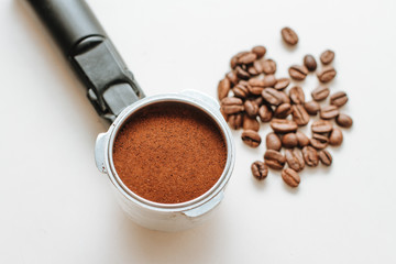 coffee horn with natural ground coffee and coffee beans on a white background