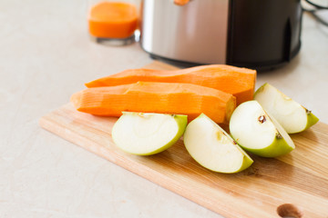 detox. smoothies. the process of making juice in the kitchen. A glass of fresh carrot juice. carrot and Apple on the table. detoxification, vegetarian diet. juicy healthy vitamin drink. juicer.