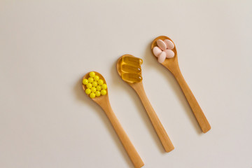 Assorted pharmaceutical medicine. Dosage. Tablets and capsules on a wooden spoon on a white background. Concept of medicine. Alternative homeopathy. Flatley. 