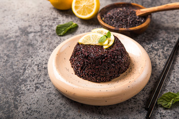 Cooked Thai black jasmine rice with chia seeds, lemon, sesame on concrete grey  background.