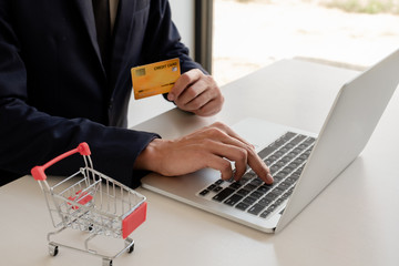 Business men use credit cards and laptops for online shopping and making payments the interne