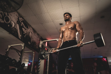 Fototapeta na wymiar Men In The Gym Exercising Biceps With Barbell
