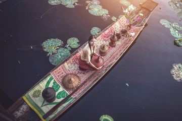 Burmese Intha woman in a rowing boat in the morning at In Dain Khone village, on Inle Lake, Myanmar.