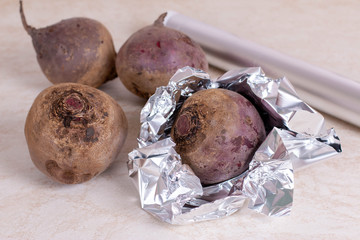 Raw red beet prepared for baking in the oven. Red beetroot wrapped in aluminum foil