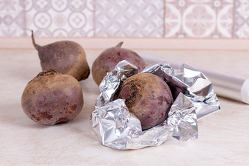 Raw red beet prepared for baking in the oven. Red beetroot wrapped in aluminum foil