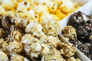 popcorn grains with cheese, caramel and chocolate, assorted background