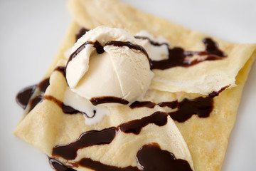 ice cream crape with chocolate sauce on white plate