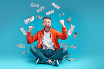 Young attractive bearded man celebrating victory after betting at bookmaker's website