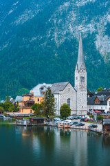 Fototapeta na wymiar Evangelical hallstatt church at lake shore alps mountains on background
