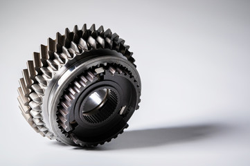 New parts on a gray background. Gears of gear shifting torque transmission. Conceptually mechanical background. Shiny gear box gear teeth