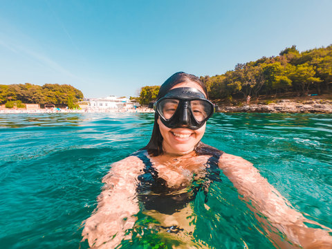 young pretty smiling woman taking selfie in snorkeling mask