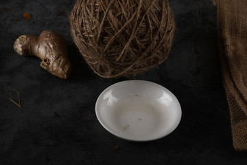A white empty ceramic saucer in a black background