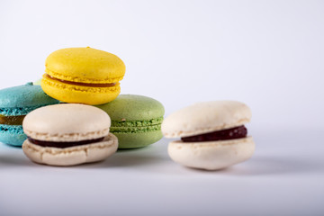 Colorful macarons isolated on white background, on the left