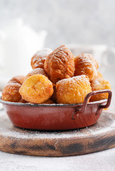 Little Donuts. Homemade curd fried cookies in deep fat and sprinkled with icing sugar in a vintage plate on a light background. Selective focus.