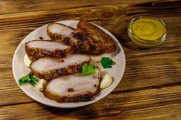 Baked pork belly in a plate on wooden table