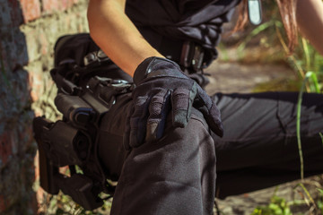 Girl in tactical clothes with a gun. Military woman. Black T-shirt and pants. Holster.SWAT