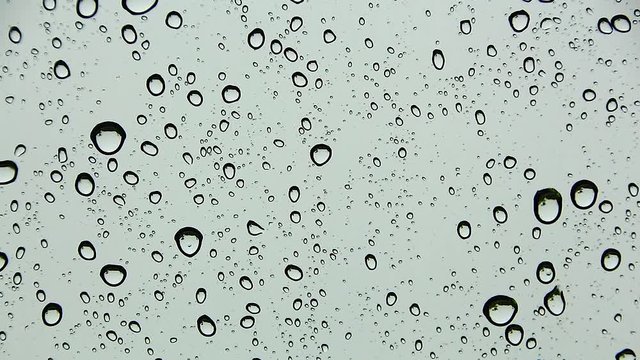 Water drop and Water droplets flow and gather on the glass, On a dark gray backdrop