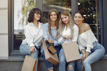 Fototapeta premium Beautiful girls in a summer city. Ladies with shopping bags