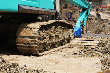 Large tracked excavator ,Excavator tractor pours the soil with Construction workers and construction engineer wearing safety helmets at construction sites background.selective focus