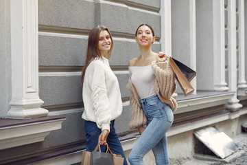 Beautiful girls in a summer city. Ladies with shopping bags