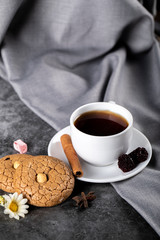 Tea with berries, cinnamon and cookies on a tablecloth