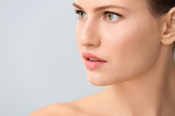 Fototapeta premium Beautiful young woman on light background. Concept of plastic surgery