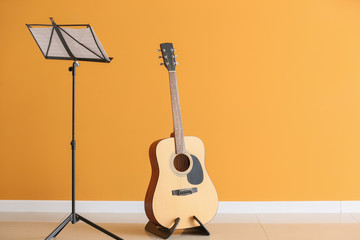 Note stand and guitar near color wall