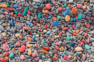 Happiness concept. Pebble coast sea of multi-colored pebbles.