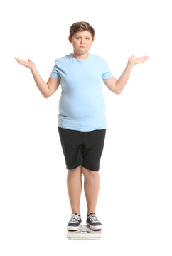 Overweight Boy Standing On Scales Against White Background