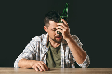 Mature man drinking beer at table