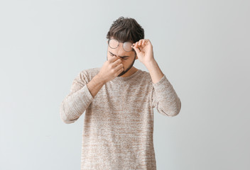 Portrait of worried young man on light background