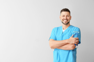 Male cardiologist on light background