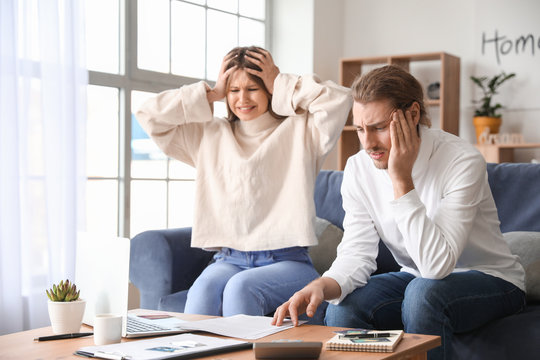 Worried Young Couple In Debt At Home