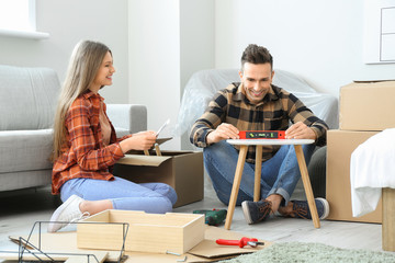 Young couple assembling furniture at home