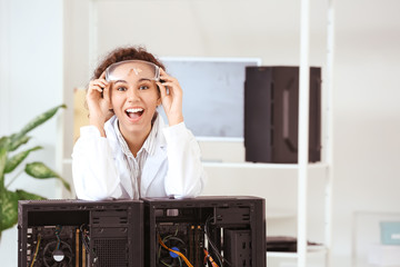Portrait of happy electronic technician in service center