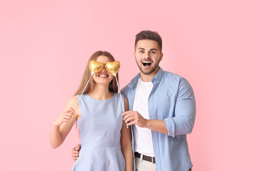 Happy young couple with hearts on color background