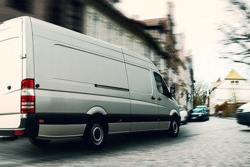Fast delivery van in a narrow street. A challenge for logistics and transportation. - obrazy, fototapety, plakaty