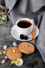 A cup of tea, almond cookies and nuts