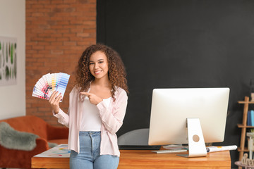 African-American designer with color palettes in office