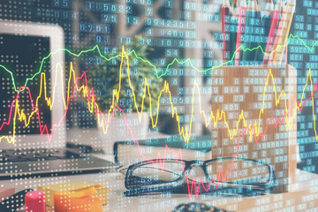 Financial chart hologram with glasses on the table background. Concept of business. Double exposure.