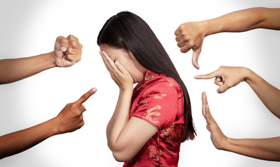 Asian woman in Chinese costume covered her face with regret for being racism and hate surrounded by...