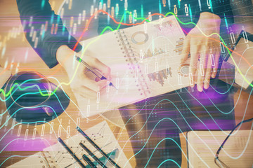 Multi exposure of hands making notes with forex chart huds. Stock market concept.