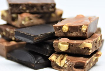 chocolate bars, black and milk chocolate with hazelnuts on a white background