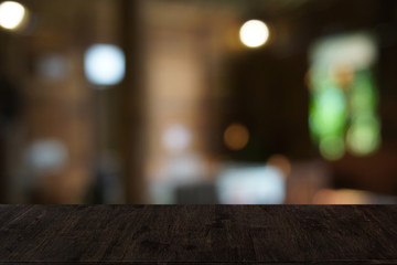 Naklejka premium Empty dark wooden table in front of abstract blurred bokeh background of restaurant . can be used for display or montage your products.Mock up for space.