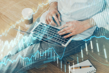 Forex graph with businessman working on computer in office on background. Concept of analysis. Double exposure.